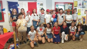 Eine Gruppe von Schülerinnen und Schülern, die mit Kostümen mit Bezug auf den Nationalfeiertag Frankreichs bekleidet sind.