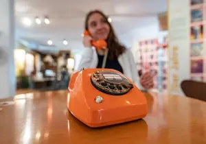 Blick in die 80er Jahre: Ein orangefarbenes Telefon mit Wählscheibe